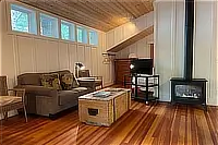 Living area with sofas, coffee table, wood ceiling, and gas fireplace.
