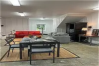 Downstairs game room with ping-pong table, sofas, and entertainment area.