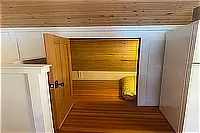Small sleeping cubby with wood-paneled walls and a bed.