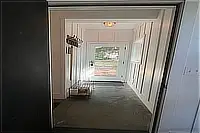 Interior hallway with white walls and doorways leading to other rooms.