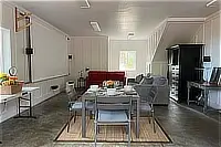Downstairs game room with ping-pong table, sofas, and large projector screen.