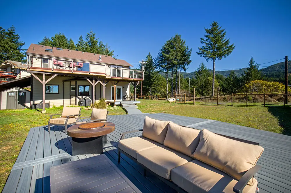 Spacious outdoor deck with firepit and lounge seating at a vacation rental home in Shelter Cove, Northern California.