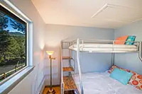 Bright bunk bedroom with forest views, perfect for families at a Shelter Cove vacation rental in Northern California.