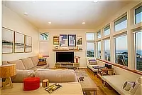 Living room with sectional sofa, television, and ocean views