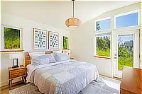 Primary bedroom with king bed and door to the outdoor deck