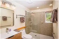 Bathroom with walk-in tiled shower and vanity