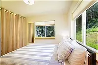 Guest bedroom with queen bed and large corner windows