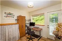 Home office with desk, computer monitor, and garden views